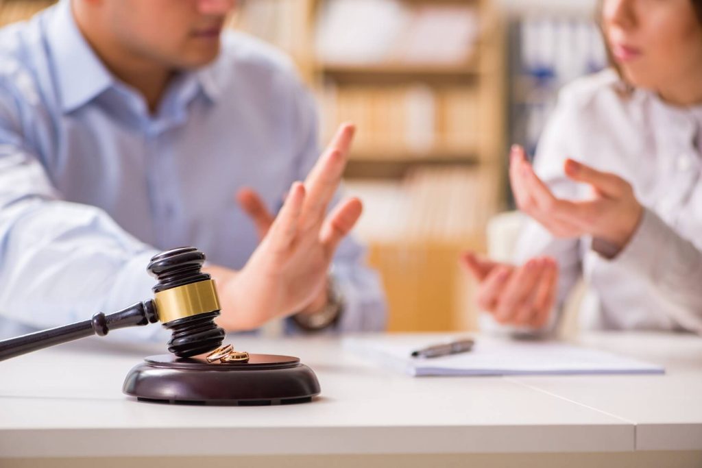Man and woman arguing sitting at a table with a judge's gavel